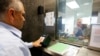 FILE - A man has his fingerprints electronically taken while taking part in a visa application demonstration.