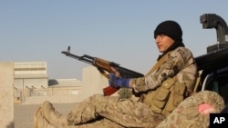 An Afghan National Army soldier rests after he arrives in a camp outside Kunduz city, north of Kabul, Afghanistan, Sept. 30, 2015.