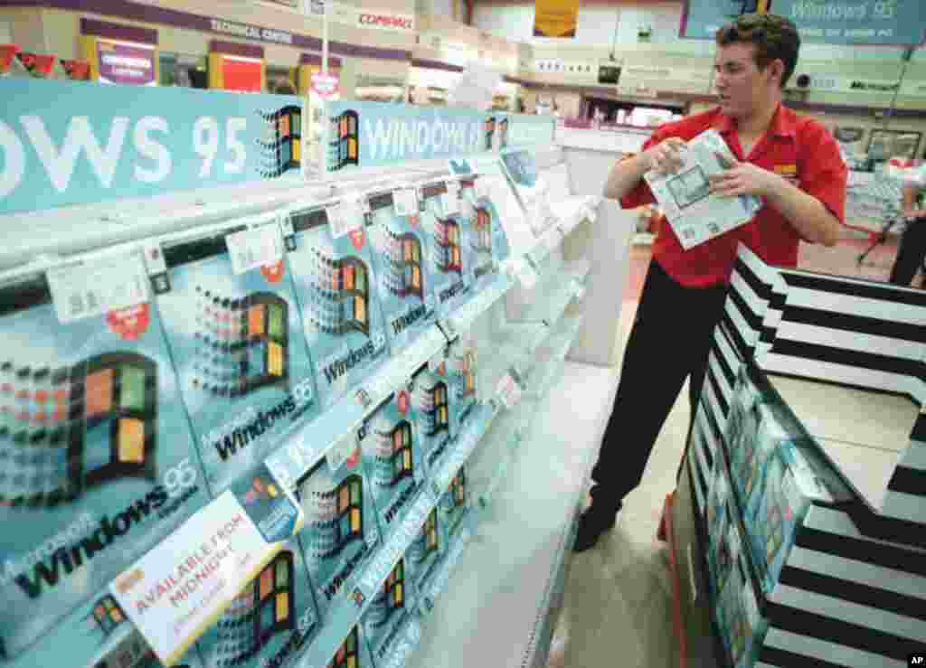 A worker packs the shelves of the computer shop PC World, at Croydon in south London, Aug. 23, 1995, with copies of the Microsoft Windows 95 computer package.