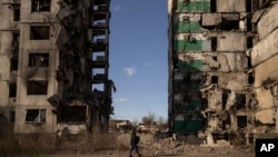 Un hombre camina junto a un bloque de apartamentos al que le falta la sección central después de ser alcanzado por un ataque aéreo, hace un año, en Borodyanka, Ucrania, el jueves 2 de marzo de 2023.