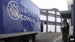 Un soldado está junto a un camión del Ministerio de Salud cargado con vacunas COVID-19 que el gobierno de El Salvador está donando y entregando a la vecina Honduras, antes de partir de San Salvador, El Salvador, el jueves 13 de mayo de 2021.
