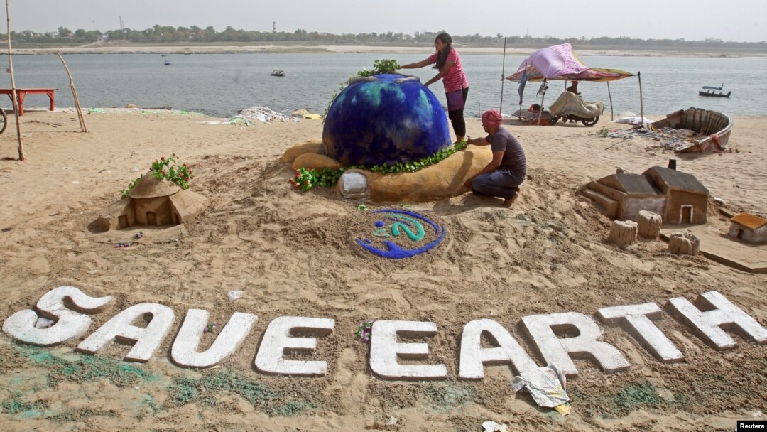 Students make a sand sculpture on the Earth Day, on the banks of the river Yamuna in Allahabad, India, April 22, 2018. REUTERS/Jitendra Prakash - RC1EA881C5B0