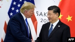 资料照片：特朗普总统与习近平主席在大阪20国集团峰会期间握手（2019年6月29日）