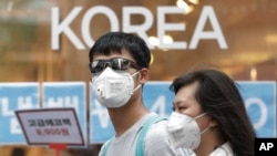 Un couple se protégeant contre le MERS en portant des masques (AP Photo/Ahn Young-joon)