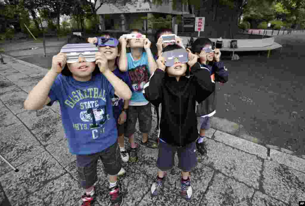 Los niños observan un eclipse solar anular en Fujisawa, Japón. .