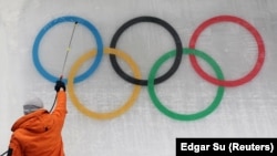Pembuat es memasang logo sub-glacial Olympic menjelang Olimpiade Musim Dingin Beijing 2022 di Yanqing National Sliding Center di Yanqing, China, 28 Januari 2022. (Foto: REUTERS/Edgar Su)