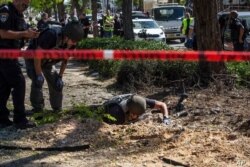 La unidad del escuadrón de bombas israelí inspecciona el sitio donde un cohete disparado desde la Franja de Gaza impactó una acera, en Ashdod, Israel, el 19 de mayo de 2021.