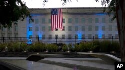 ARCHIVO - Una bandera estadounidense se despliega en el Pentágono en Washington, el sábado 11 de septiembre de 2021, al amanecer en la mañana del 20 aniversario de los ataques terroristas.