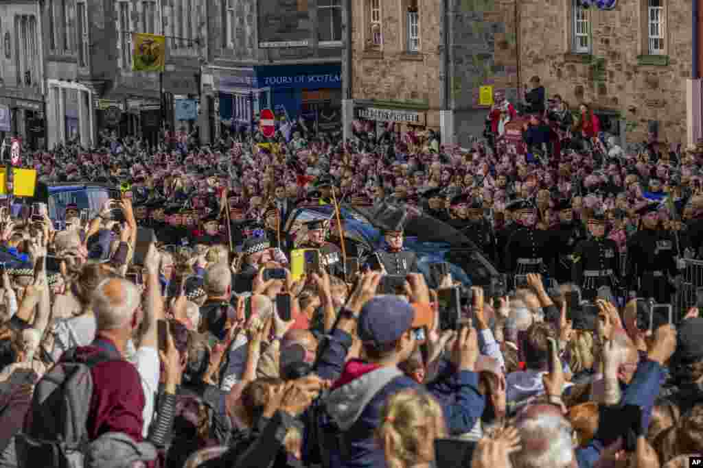 People attend the procession of Queen Elizabeth II's coffin, from the Palace of Holyroodhouse to St. Giles' Cathedral, on the Royal Mile in Edinburgh, Sept. 12, 2022.