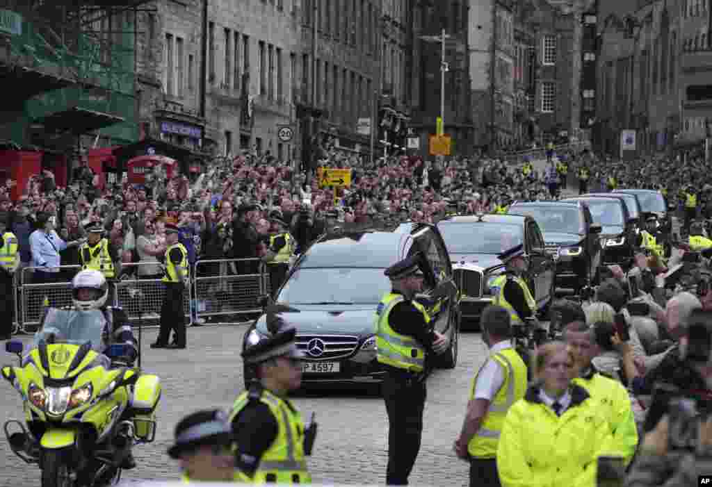 The Queen's cortege with the hearse containing her coffin makes its way down the Royal Mile in Edinburgh, Scotland, Sept. 11, 2022.