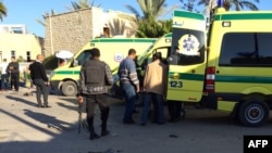 Petugas pertolongan darurat dan petugas keamanan berdiri di dekat ambulan menyusul serangan di sebuah hotel di luar kota EL-Arish, Semenanjung Sinai, Mesir (24/11). 
