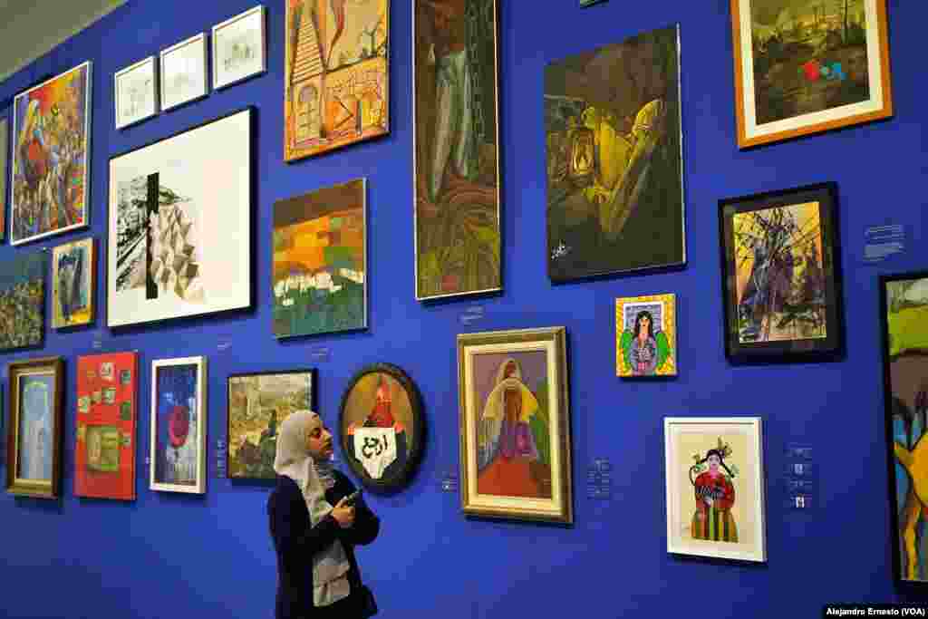 Una joven palestina recorre la muestra "Esto no es una exposición", en Birzeit, que estará abierta al público mientras dure la guerra en Gaza.