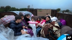Ethnic Armenians from Nagorno-Karabakh sit in a truck on their way to Kornidzor in Armenia's Syunik region, Sept. 25, 2023. 