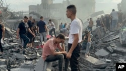 FILE - Palestinians look for survivors following an Israeli airstrike in Nusseirat refugee camp, Gaza Strip, Oct. 31, 2023. 