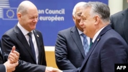 Germany's Chancellor Olaf Scholz (L) shakes hands with Hungary's Prime Minister Viktor Orban as they speak prior to the start of a European Council meeting at the European headquarters in Brussels, on Feb. 1, 2024.