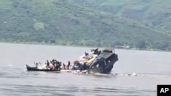 In this video frame grab, a boat sinks in the Congo river outside Kinshasa, Democratic Republic of Congo, Feb. 12, 2024.