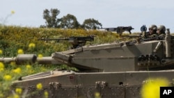 ARCHIVO - Soldados israelíes sobre un tanque cerca de la frontera entre Israel y Gaza, visto desde el sur de Israel, el 21 de marzo de 2024.