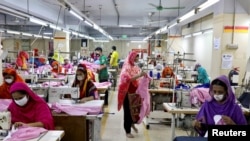FILE - Women work in a garment factory in Dhaka, Bangladesh, May 3, 2020. Most garment factories in Bangladesh reopened on Tuesday after being closed recently because of widespread protests.