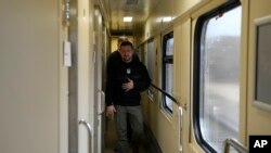El presidente de Ucrania, Volodymyr Zelenskyy, camina por un pasillo a su llegada para una entrevista con The Associated Press en un tren camino de la región de Sumy a Kiev, Ucrania, el martes 28 de marzo de 2023. (AP Foto/Efrem Lukatsky )
