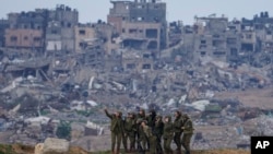 Mulheres-soldado israelitas fazem uma selfie na fronteira Sul de Israel com Gaza, 19 fevereiro 2024 (AP Photo/Tsafrir Abayov)