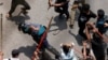 Seorang polisi dipukuli oleh massa saat bentrokan antara para pendukung antikuota, polisi dan pendukung Liga Awami di wilayah Rampura, di Dhaka, Bangladesh, Kamis, 18 Juli 2024. (Foto: Mohammad Ponir Hossain/Reuters)
