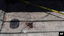 La sangre mancha la acera cerca de la entrada de la casa donde el periodista Armando Linares fue asesinado a tiros, en Zitácuaro, estado de Michoacán, México, el 16 de marzo de 2022.