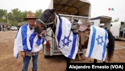 El doctor Am, veterinario, y su yegua Mika posan ataviados con banderas de Israel durante la cabalgata por la liberación del joven Idan Shtivi, el 5 de diciembre de 2023.