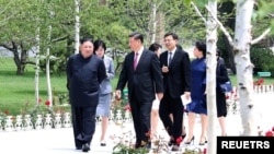 ARCHIVO - El líder norcoreano Kim Jong Un camina con el presidente chino Xi Jinping durante la visita de Xi a Pyongyang, Corea del Norte, en esta imagen publicada por la Agencia Central de Noticias de Corea del Norte (KCNA, por sus siglas en inglés), el 21 de junio de 2019.