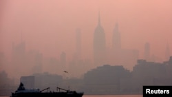 The Empire State Building in midtown Manhattan in New York City is pictured shortly after sunrise as haze and smoke caused by wildfires in Canada hangs over the Manhattan skyline in as seen from Jersey City, New Jersey, June 8, 2023. 