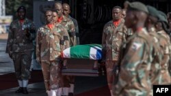 Des membres des Forces de défense nationales sud-africaines portent un cercueil lors de la cérémonie funéraire du capitaine Simon Mkhulu Bone et du caporal Irven Thabang Semono à la base aérienne de Waterkloof, le 21 février 2024. AFP / Marco Longari
