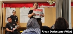 Petugas KPPSLN Pos menunjukkan surat suara pilpres yang sudah digunakan pemilih ke hadapan saksi untuk menentukan keabsahannya.