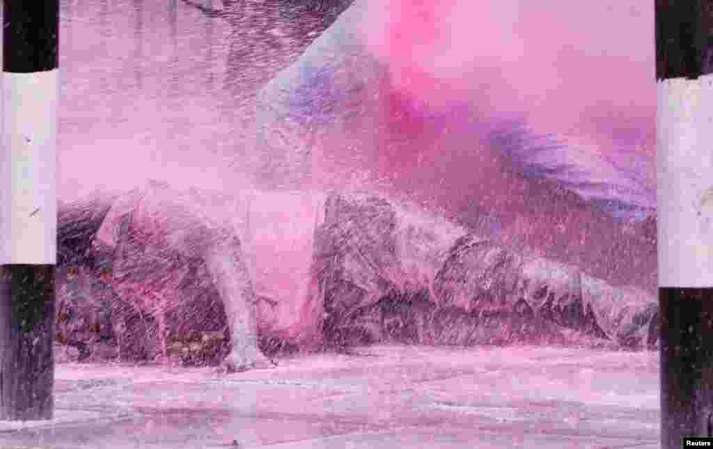 A man falls after police use water cannon to disperse protesters during a demonstration against Kenya's proposed finance bill 2024/2025 in Nairobi.