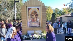 El anda del Señor de los Milagros rodeado por sus feligreses vestidos de morado.