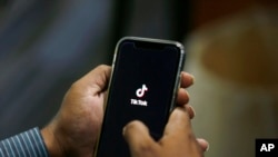 FILE - A man opens social media app TikTok on his cellphone, in Islamabad, Pakistan, July 21, 2020.
