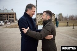 El presidente de Ucrania, Volodymyr Zelenskiy, da la bienvenida al primer ministro de Bélgica, Alexander De Croo, en un aeródromo en la ciudad de Hostomel, en el segundo aniversario de la invasión rusa de Ucrania, en las afueras de Kiev, el 24 de febrero de 2024.