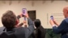 Los invitados fotografían la placa en honor a la VOA como un sitio histórico en el periodismo, el 2 de febrero de 2024 en Washington. (Cristina Caicedo Smit/VOA)