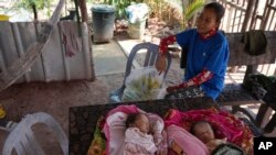 ທ້າວ ຄຽງ ພິດ​ພາ​ນິດ, ອາ​ຍຸ 24 ປີ, ຜູ້​ທີ່​ຖືກ​ຍົກ​ຍ້າຍ​ອອກ​ຈາກ​ສະ​ຖານ​ທີ່​ບູ​ສະ​ນິ​ຍະ​ສະ​ຖານ​ຂອງ ກຳ​ປູ​ເຈຍ, ນັ່ງ​ໃກ້​ລູກ​ແຝດ​ຂອງ​ລາວ​ຢູ່​ເຮືອນ​ຂອງ​ລາວ​ໃນ​ບ້ານ ຣັນ ຕາ ເອັກ, ແຂວງ ຊຽມ ຣຽບ, ກຳ​ປູ​ເຈຍ, 2 ເມ​ສາ 2024.