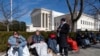 Gente hace fila frente a la Corte Suprema de EEUU para poder asistir a la audiencia que decidirá si el expresidente Donald Trump está inhabilitado para presentarse como candidato en 2024, 7 de febrero de 2024, en Washington. 