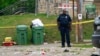 A police officer stands in the area of a mass shooting incident in the Southern District of Baltimore, July 2, 2023. 