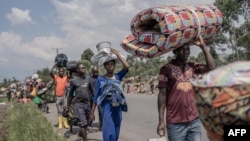 Des personnes sur une route près de Sake, fuient le territoire de Masisi suite aux affrontements entre rebelles du M23 et forces gouvernementales, le 7 février 2024. AFP / Aubin Mukoni