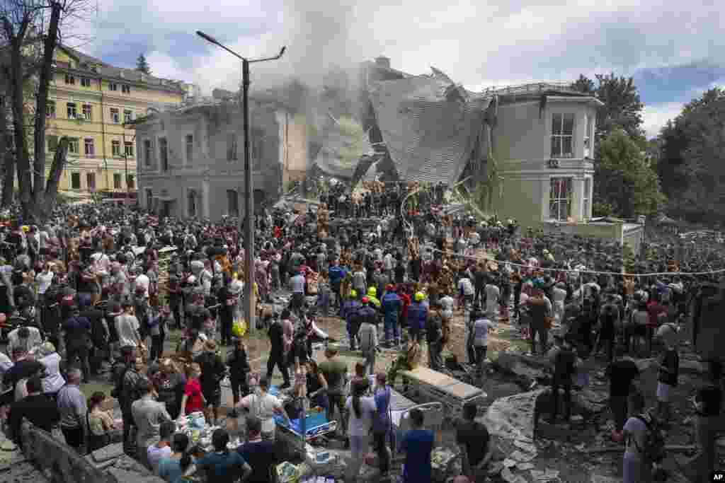 Rescuers and volunteers clean up the rubble and search victims after Russian missile hit the country's main children hospital Okhmadit in Kyivd during massive missile attack on many Ukrainian cities,