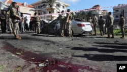 Lebanese army soldiers gather around a damaged car near the coastal town of Jadra, south Lebanon, Feb. 10, 2024.