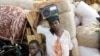 Mwanamke mkimbizi akiwa amebeba redio akiwa kwenye ufukwe wa ziwa Tanganyika Picha na REUTERS/Thomas Mukoya