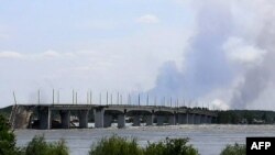 Esta vista general muestra un área parcialmente inundada cerca del Puente Antonovskiy (REAR) en las afueras de Jersón, el 6 de junio de 2023, luego de los daños sufridos en la represa hidroeléctrica Kakhovka.