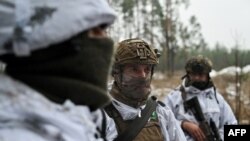 Militares ucranianos vestidos con camuflaje de nieve participan en un entrenamiento militar en un lugar no revelado en la región de Kharkiv, Ucrania, el 1 de diciembre de 2023.