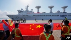斯里蘭卡港口工人在中國一帶一路項目漢班托塔港手持中國國旗歡迎一艘中國考察船到港。（2022年8月16日）