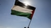 FILE - Houthi followers hold a Palestinian flag during a parade in solidarity with the Palestinians in the Gaza Strip and to show support for Houthi strikes on ships in the Red Sea and the Gulf of Aden, in Sanaa, Yemen, Jan. 29, 2024. 