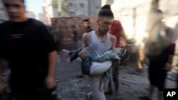Palestinos evacuan a los sobrevivientes después de los ataques aéreos israelíes contra edificios en Deir al Balah, Franja de Gaza, el 7 de noviembre de 2023.
