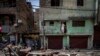 FILE - A Muslim man watches from his house after a shop was demolished in the area that saw communal violence during a Hindu religious procession in New Delhi's northwest Jahangirpuri neighborhood, in New Delhi, India, April 20, 2022.