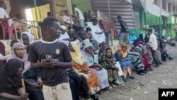 FILE - People from states of Khartoum and al-Jazira, displaced by the ongoing conflict in Sudan between the army and paramilitaries, wait to receive aid from a charity organisation in Gedaref on Dec. 30, 2023. 